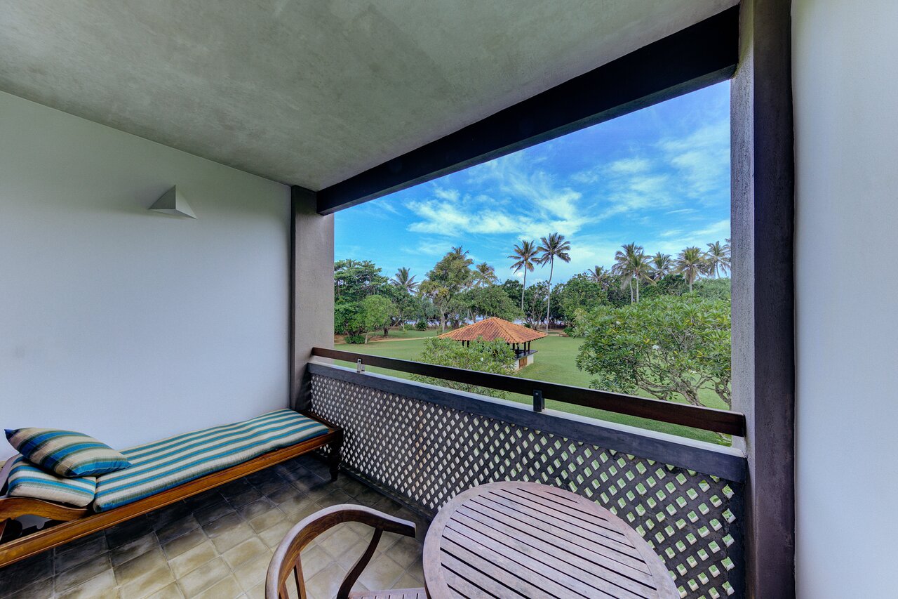 Cinnamon Bey viesnīcas balkons ar skatu uz dārzu un palmām.