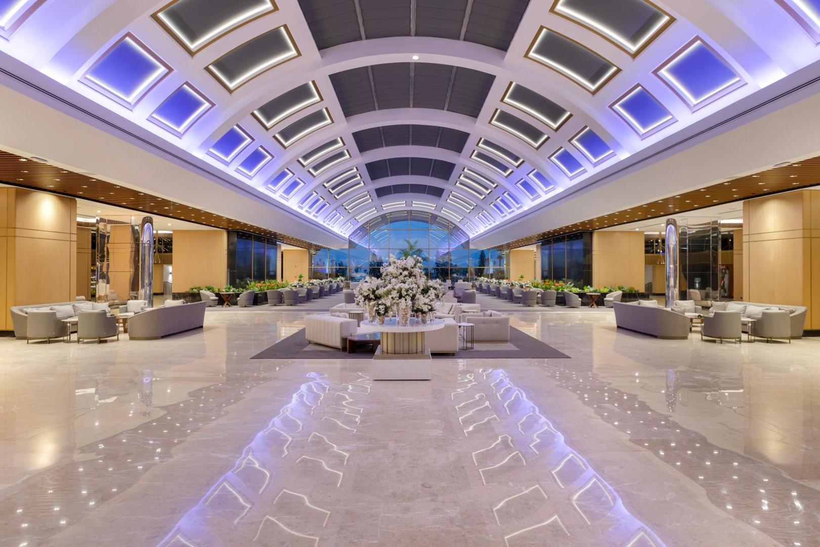 Miracle Resort Hotel plašais un modernais lobby ar augstiem, izgaismotiem griestiem, marmora grīdu un ērtām atpūtas zonām viesu uzņemšanai.