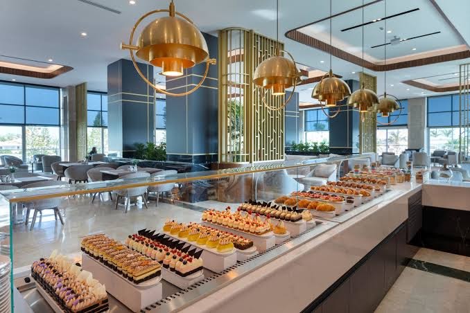 Miracle Resort Hotel restorāna bufetes zona ar plašu kūku, kūciņu un desertu izvēli elegantā interjerā