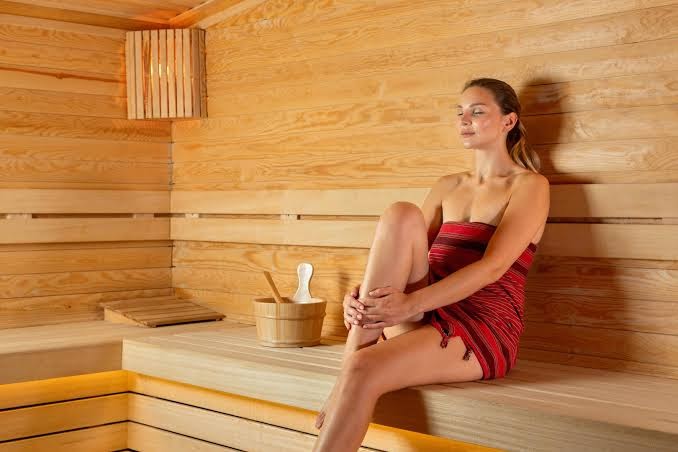 Miracle Resort Hotel spa centra sauna ar koka apdari un relaksācijas zonu Antalijā — sieviete atpūšas mierīgā gaisotnē