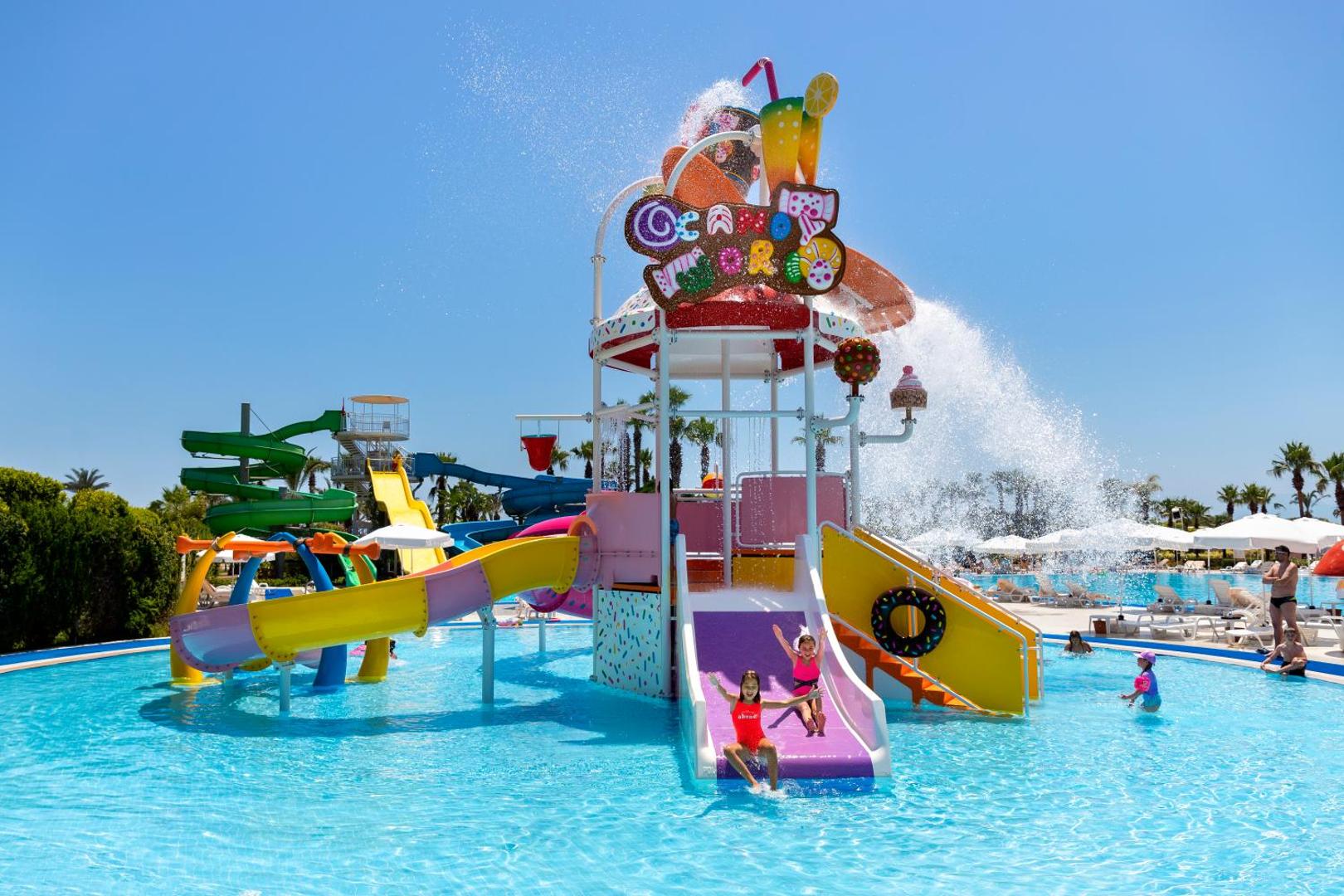 Miracle Resort Hotel lielais akvaparks ar vairākiem ūdens slidkalniņiem un bērnu baseinu saulainā dienā Antalijas reģionā