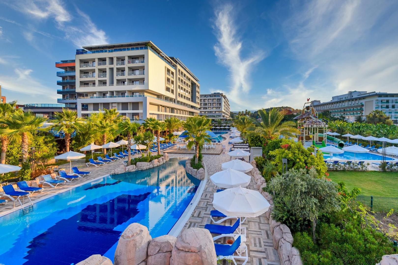 Panorāmas skats uz Numa Bay Exclusive Hotel teritoriju ar vairākiem baseiniem, bērnu ūdens atrakcijām un palmām