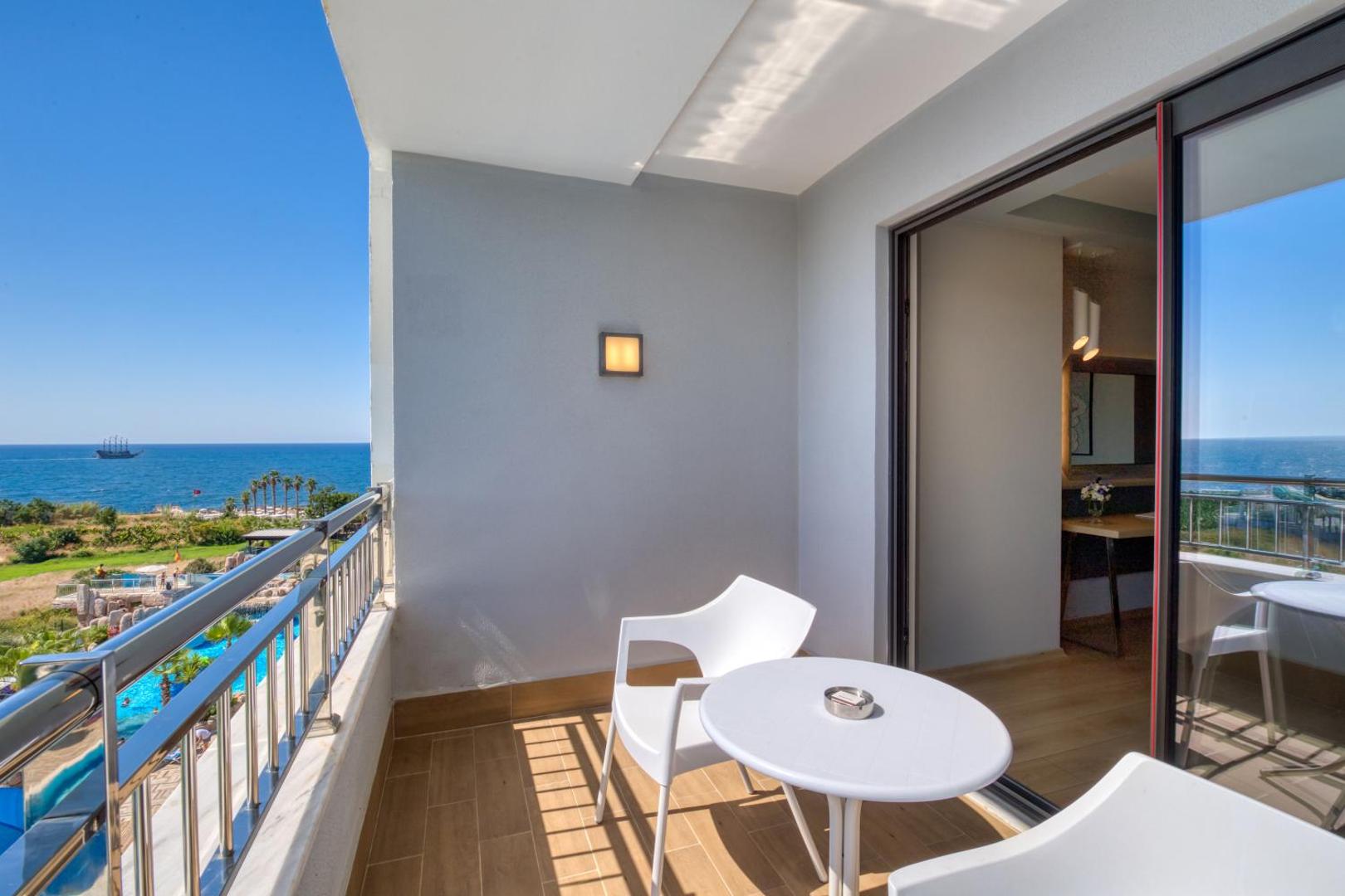 Skats no Numa Bay Exclusive Hotel balkona uz viesnīcas teritoriju, baseiniem un jūru saulainā dienā