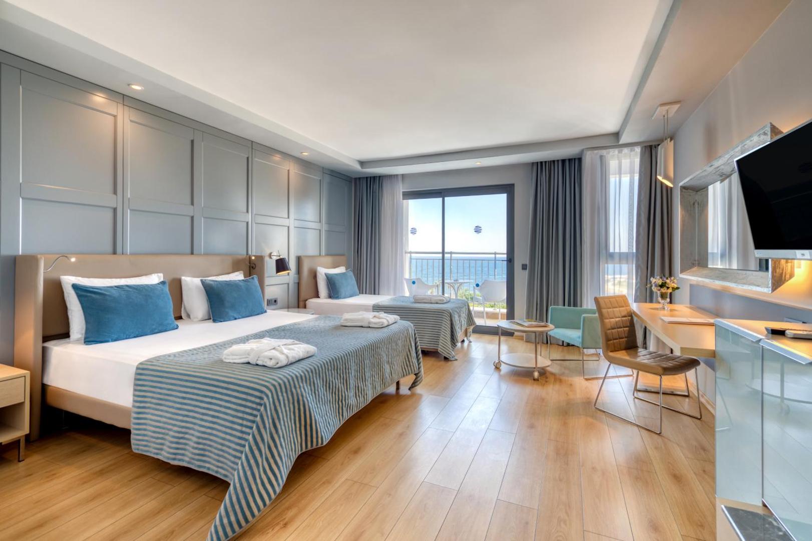 Numa Bay Exclusive Hotel gaišs numurs ar divām gultām, koka grīdu un balkonu ar skatu uz Vidusjūru Alanjas reģionā