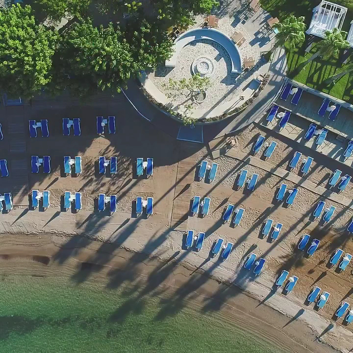 Numa Bay Exclusive Hotel privātā pludmale no putna lidojuma ar ziliem sauļošanās krēsliem un dzidru jūras ūdeni Alānijā