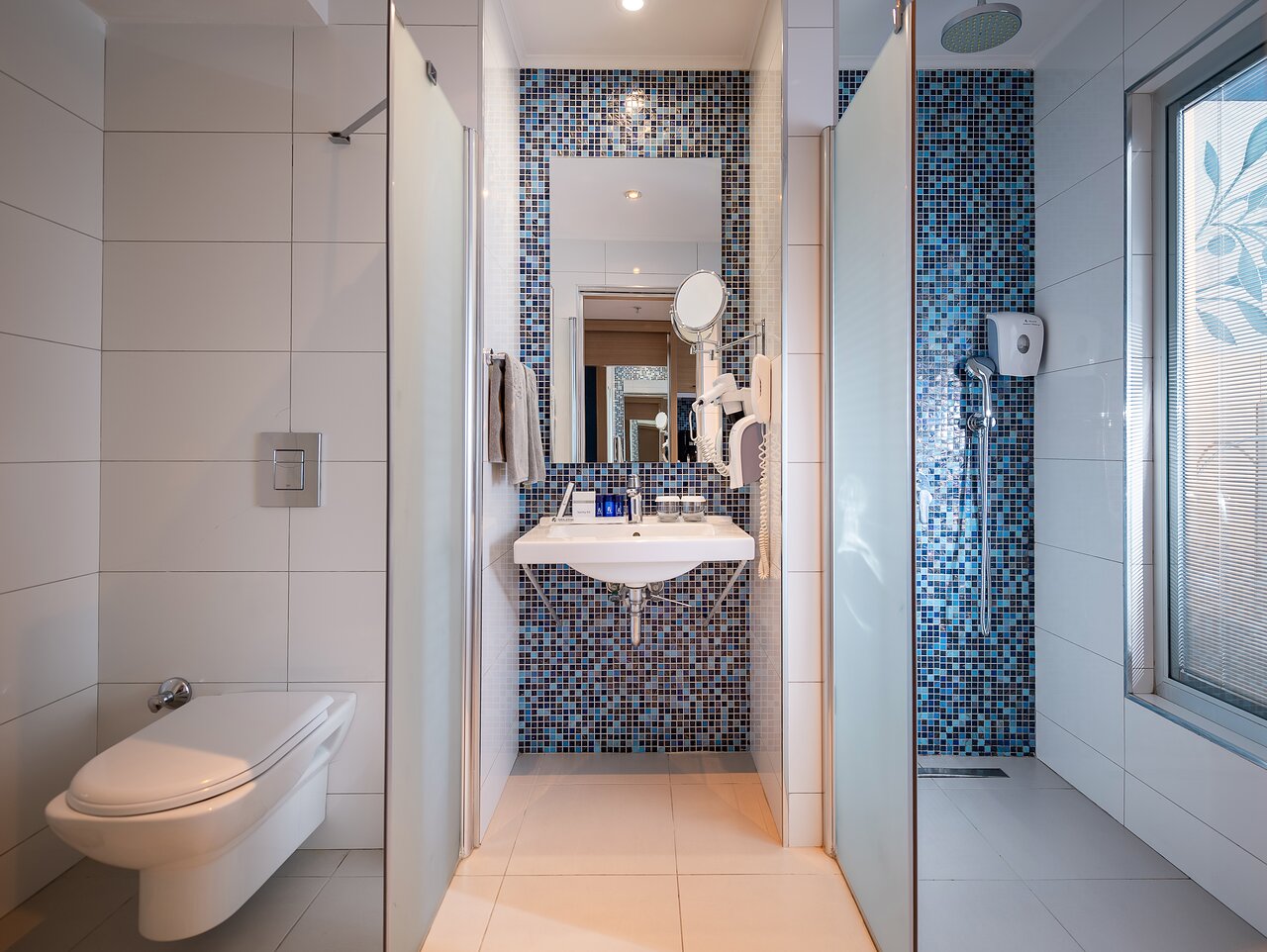 Selene Beach and Spa Hotel numura vannas istaba ar zilu mozaīkas sienu, dušu, izlietni un tualeti gaišos toņos