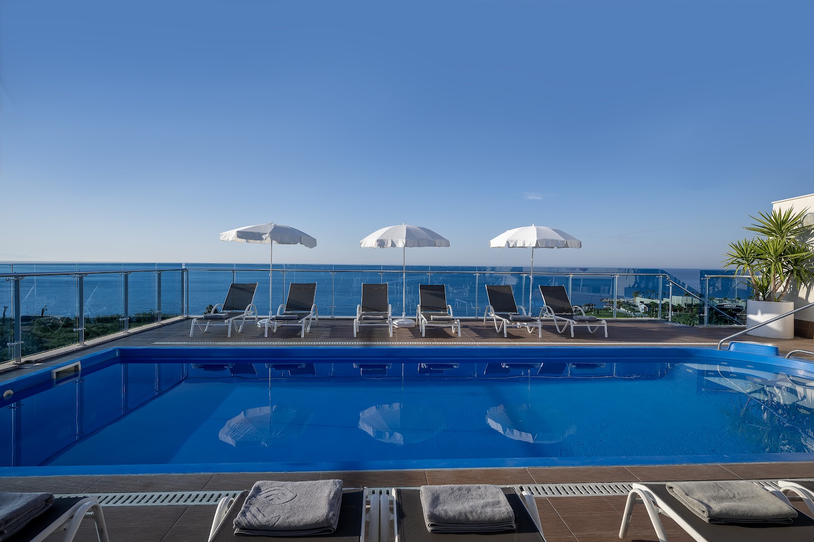 Selene Beach and Spa Hotel jumta baseins ar stikla margām un panorāmas skatu uz Vidusjūru, sauļošanās krēsli un saulessargi