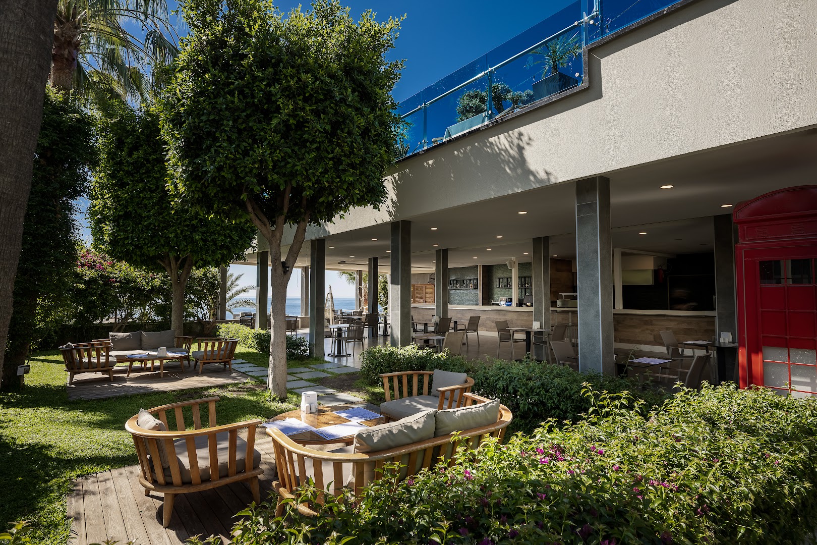 Selene Beach and Spa Hotel āra bārs un dārza terase ar koka mēbelēm, zaļumiem un skatu uz jūru