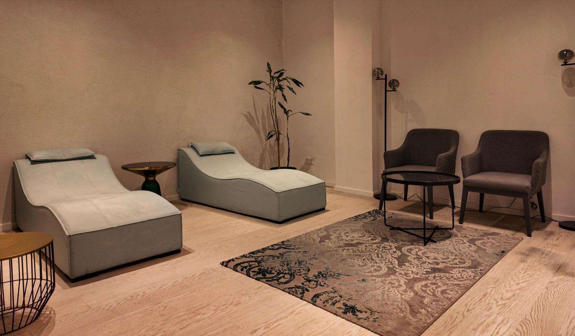Radisson Beach Resort Larnaca spa relaksācijas telpa ar mīkstiem zviļņiem, atpūtas krēsliem un mierīgu apgaismojumu atjaunojošai atpūtai.