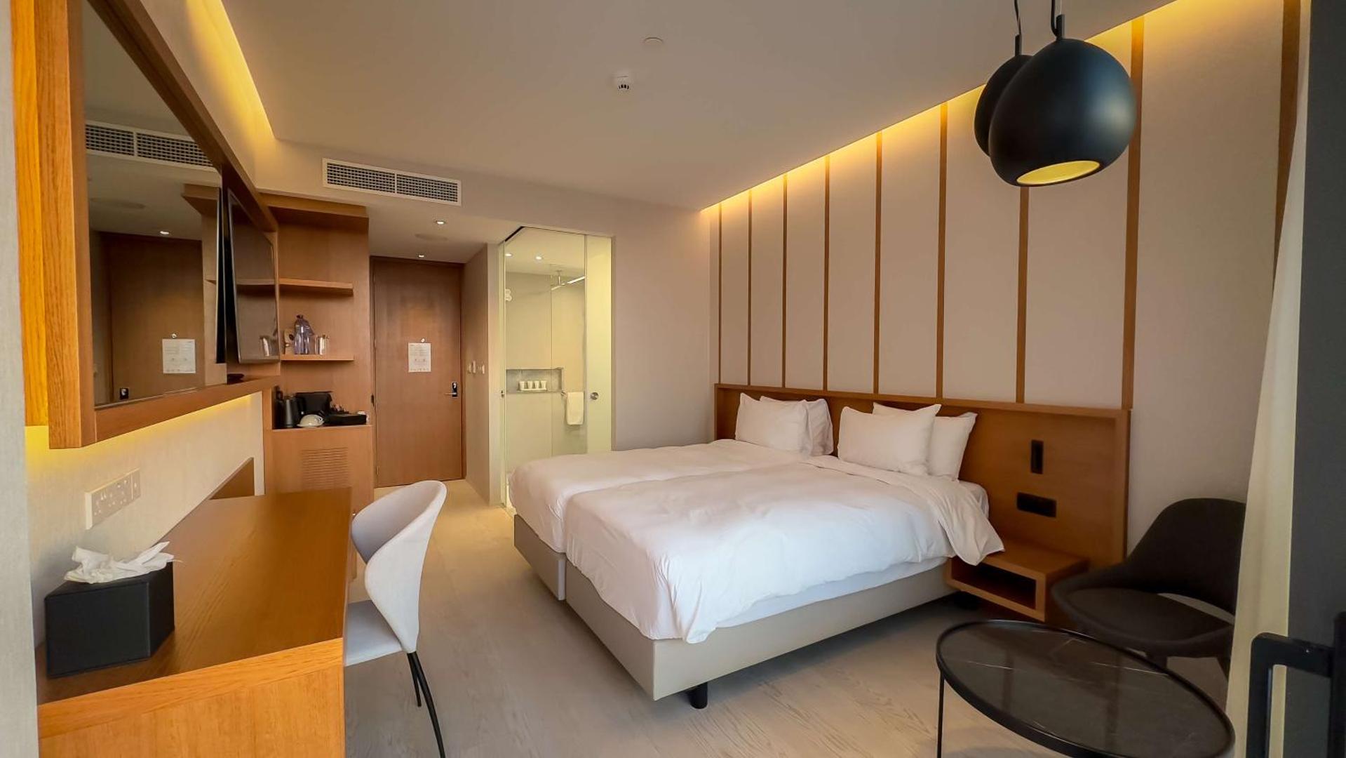 Radisson Beach Resort Larnaca numurs ar divām gultām, rakstāmgaldu un caurspīdīgu vannas istabas sienu