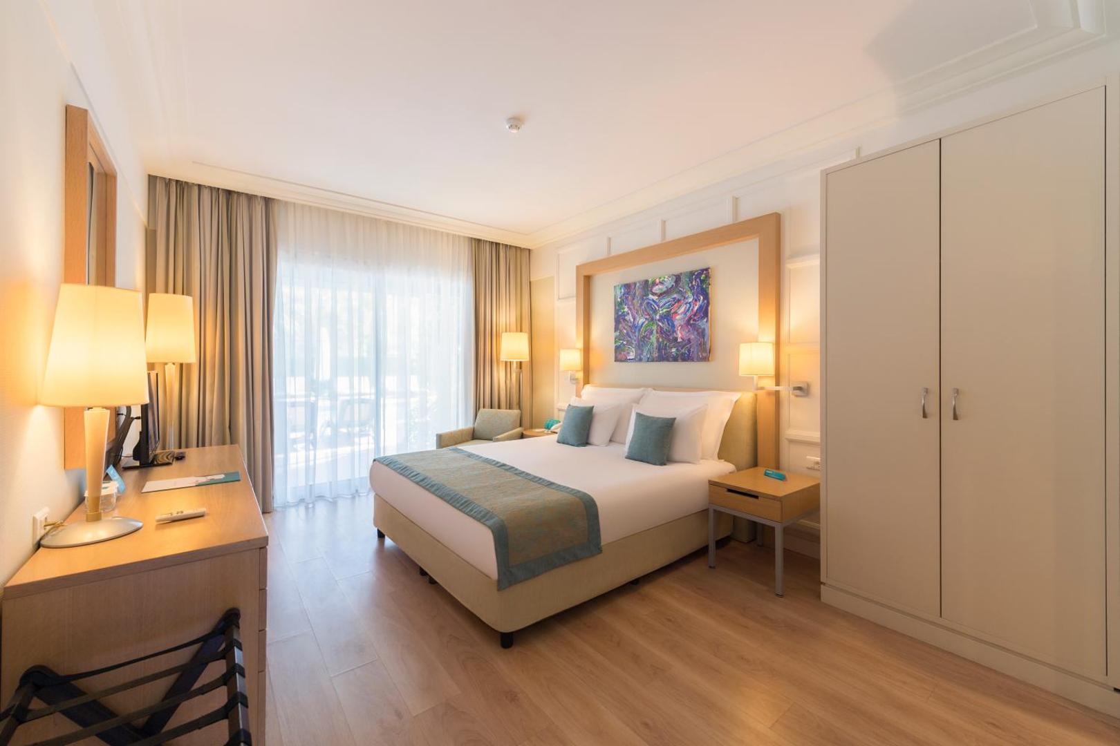 Turquoise Hotel moderns numurs ar divguļamo gultu, lielu skapi un panorāmas logu uz dārzu