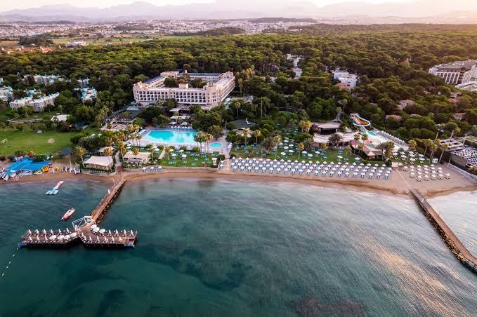 Skats no putna lidojuma uz Turquoise Hotel privāto pludmali, koka piestātni un zilo Vidusjūras ūdeni
