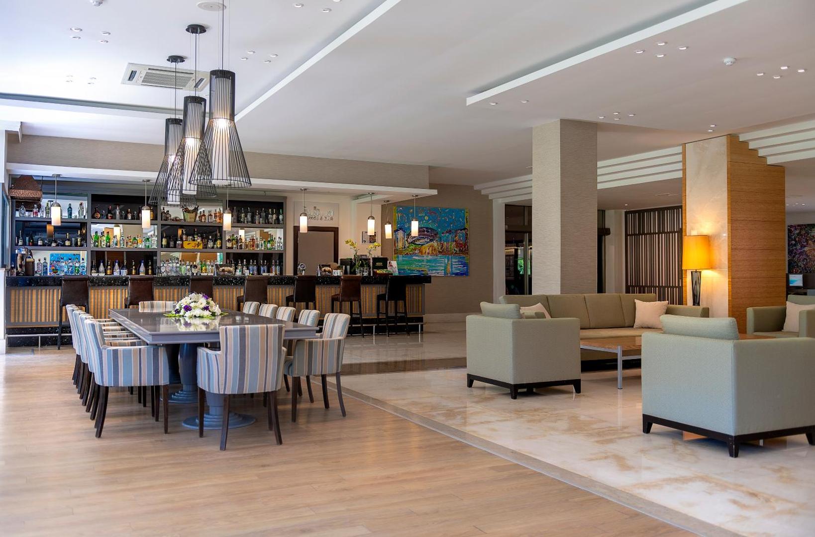 Turquoise Hotel modernais vestibila bārs un atpūtas zona ar mīkstajiem krēsliem, dizaina gaismekļiem un plašu dzērienu izvēli pie letes