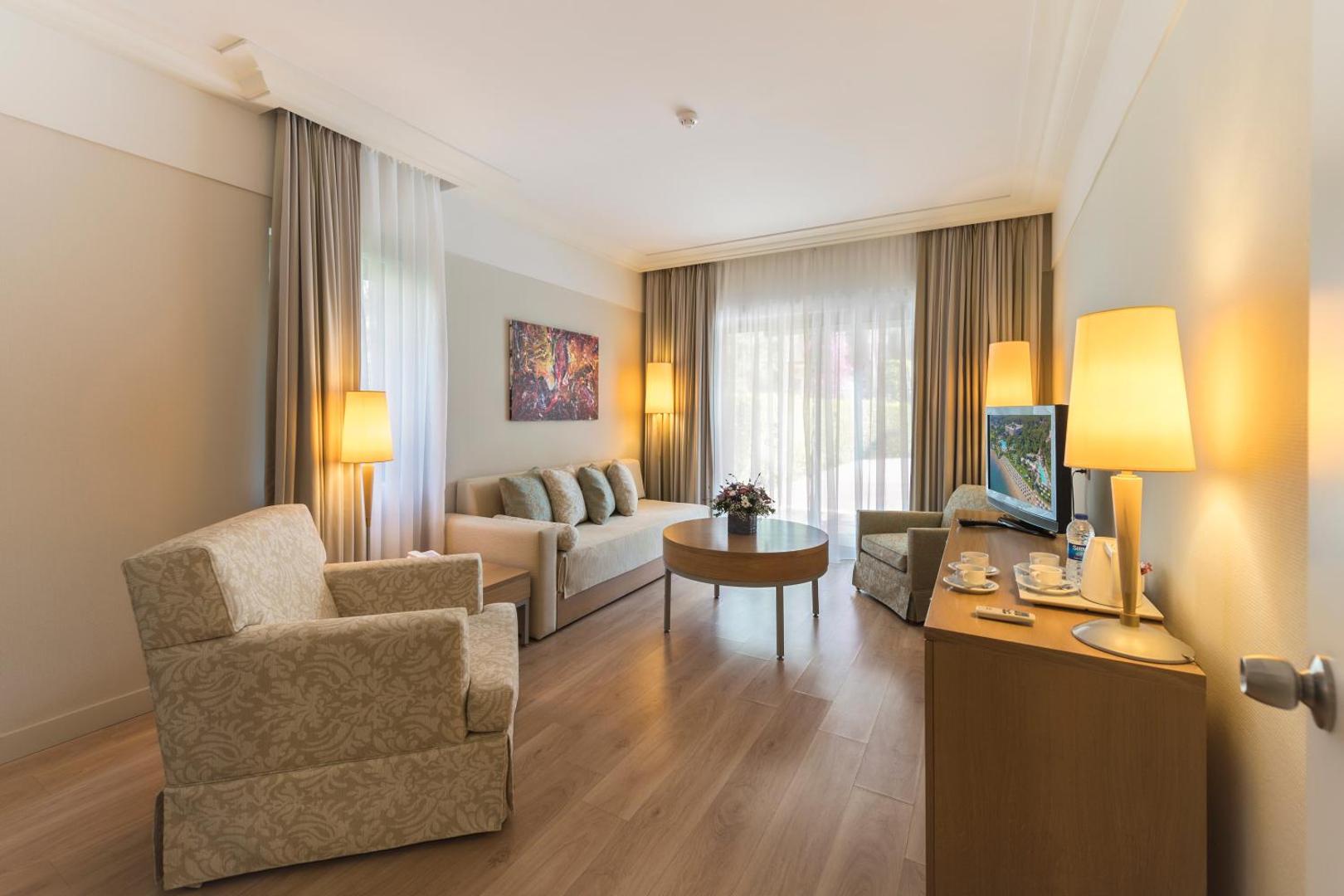 Turquoise Hotel numura viesistabas zona ar dīvānu, kafijas galdiņu un krēslu — plašs numurs ģimenes atpūtai