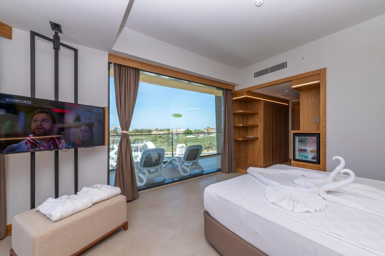 Sorgun Akadia Hotel Luxury gaišs numurs ar skatu uz dārzu, balkonu un lielu gultu — mūsdienīgs interjers ar koka elementiem