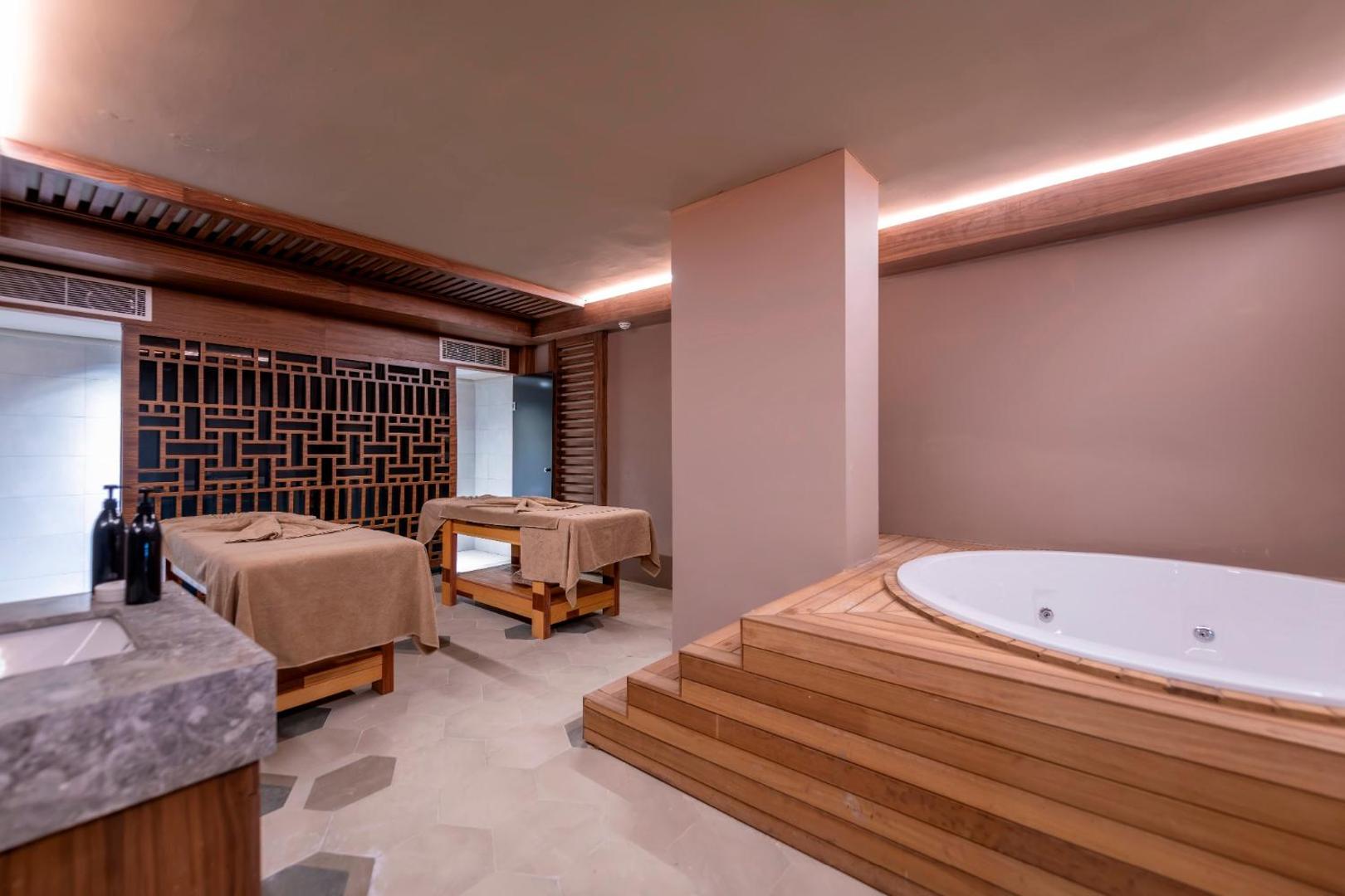 Sorgun Akadia Hotel Luxury spa procedūru telpa ar masāžas galdiem un džakuzi vannu koka apdarē