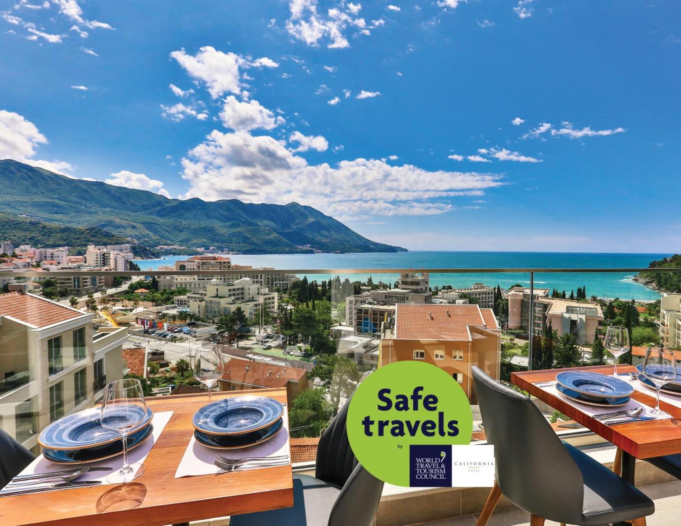 Hotel Lusso Mare restorāna terase ar skatu uz Adrijas jūru un kalniem Bečiči kūrortā, Melnkalnē — klāti galdi āra zonā