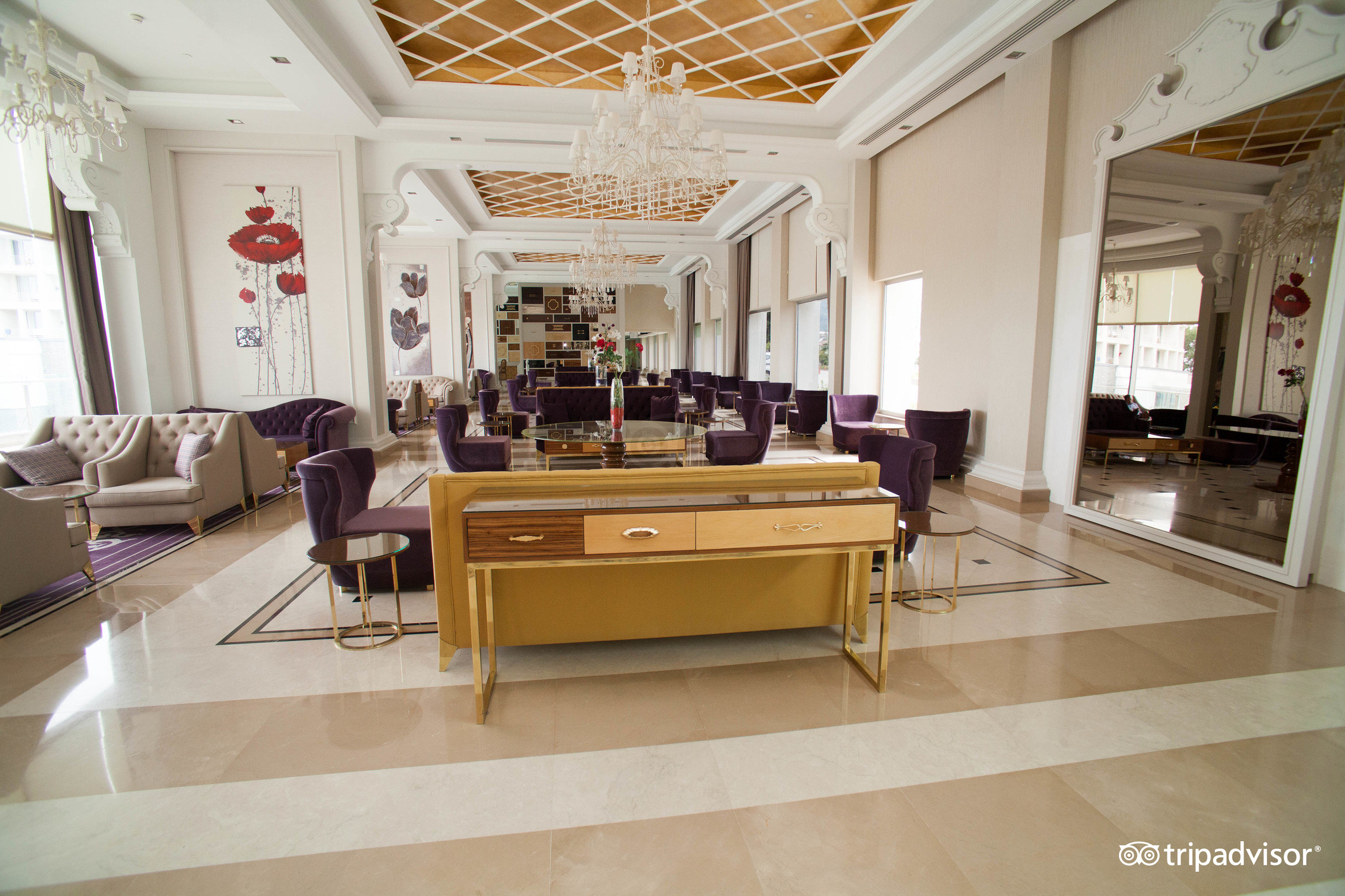 Kilikya Palace Goynuk grezna lobby atpūtas zona ar violetiem krēsliem, kristāla lustrām un marmora grīdu elegantā stilā