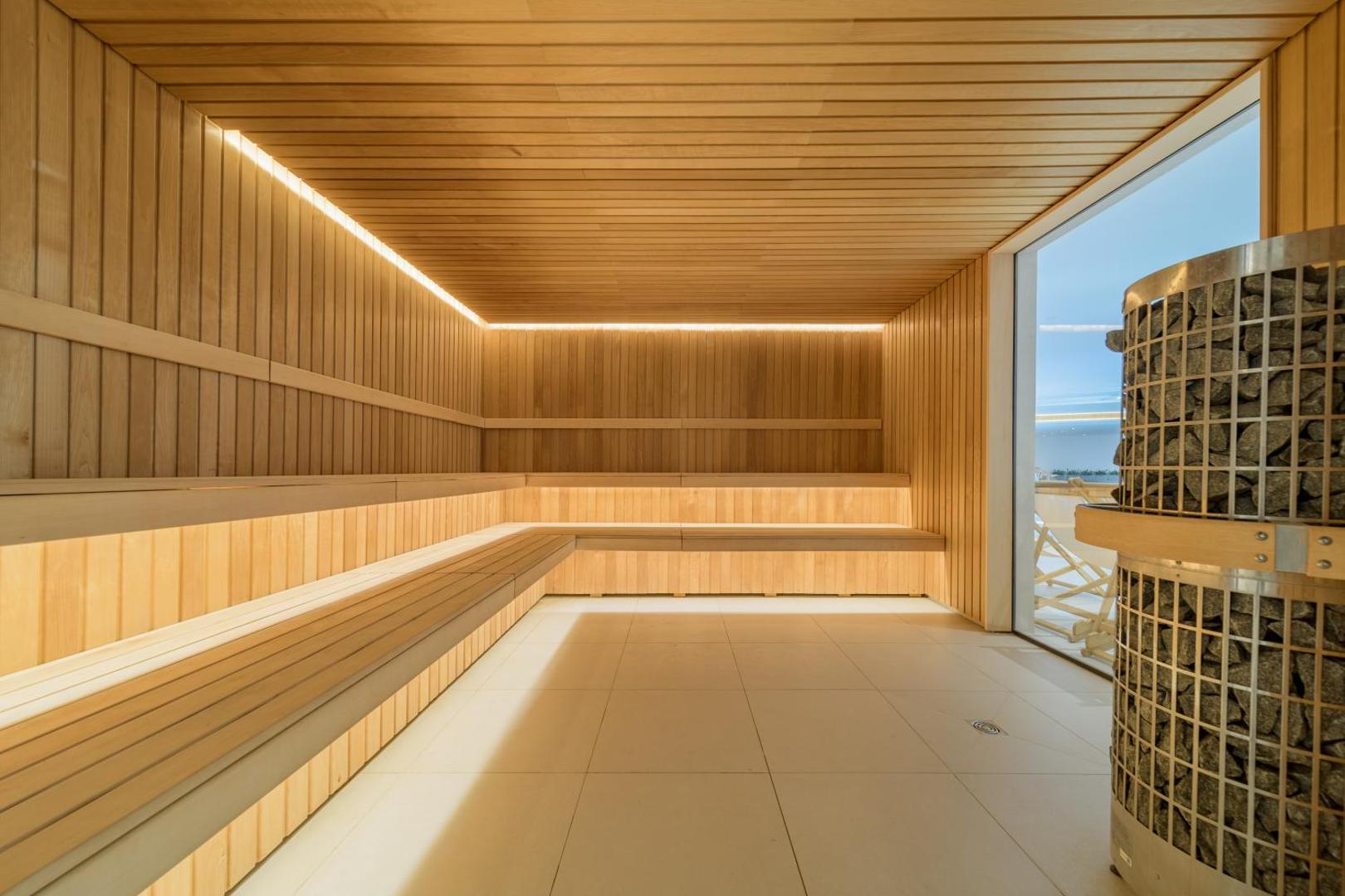 Aquahouse Hotel & SPA spa centra sauna ar koka apdari, mīkstu apgaismojumu un skatu caur lielu logu