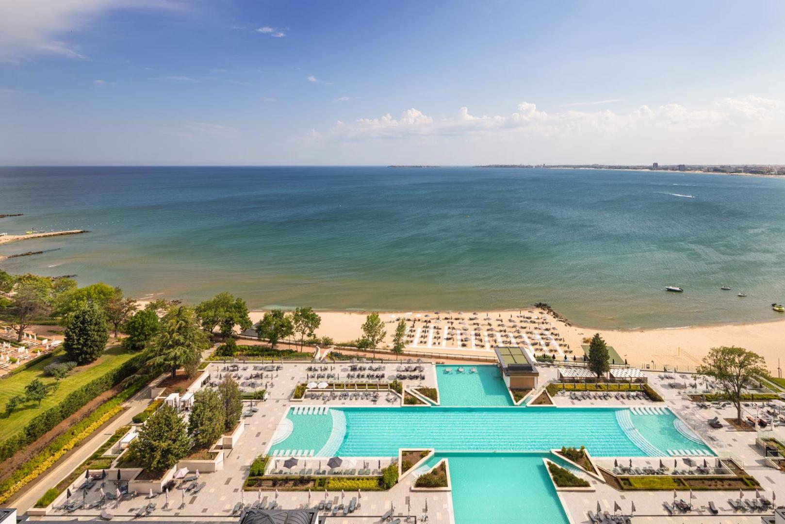 Panorāmas skats no augšas uz Secrets Sunny Beach Resort and Spa baseinu kompleksu, pludmali un Melno jūru