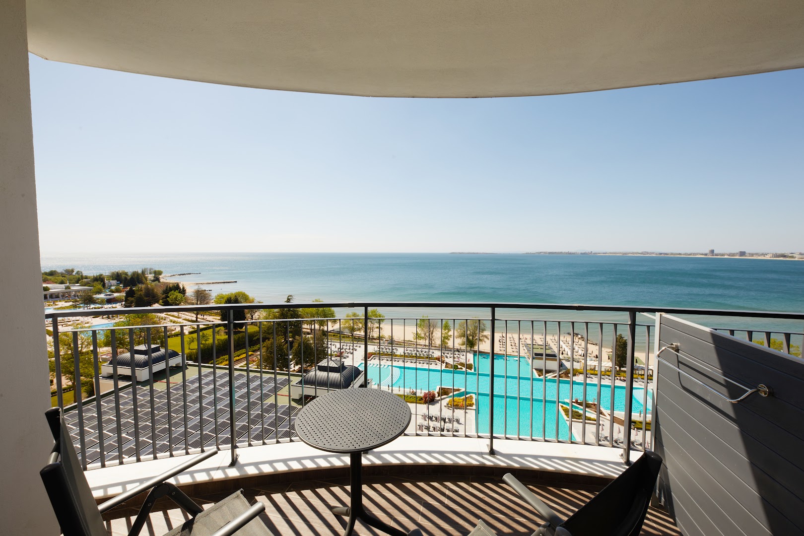 Skats no Secrets Sunny Beach Resort and Spa balkona uz viesnīcas baseiniem, pludmali un Melno jūru Saulainajā krastā