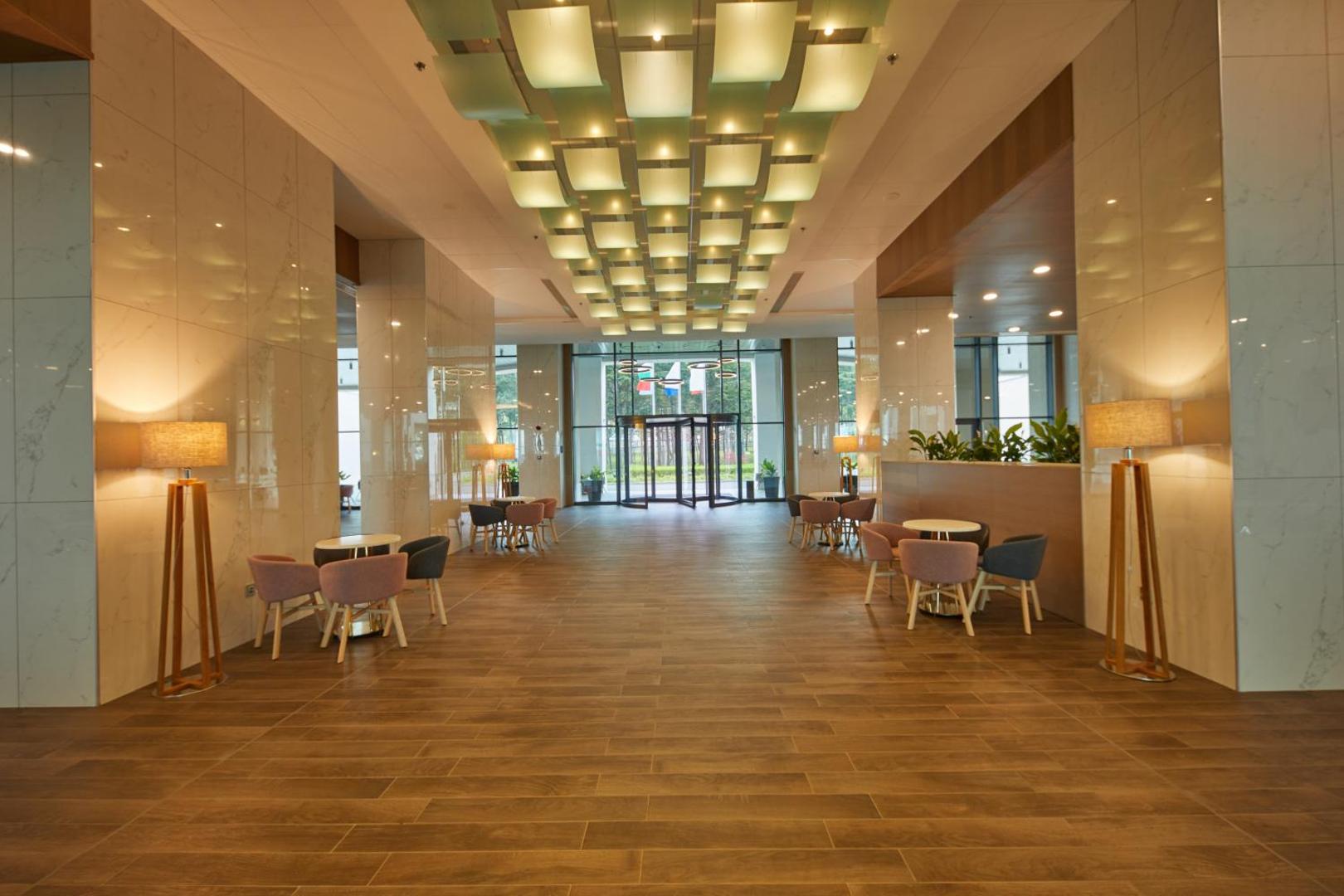 Secrets Sunny Beach Resort and Spa viesnīcas vestibils ar marmora sienām, modernu apgaismojumu un atpūtas zonām pie ieejas