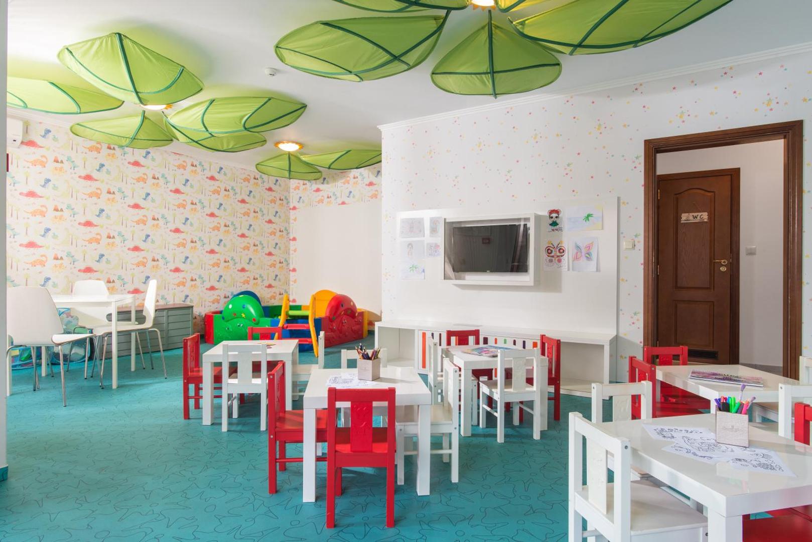 Diamant Residence Hotel & Spa bērnu rotaļu istaba ar maziem galdiņiem, krēsliem un krāsainiem sienu dekoriem — droša vide bērnu izklaidei