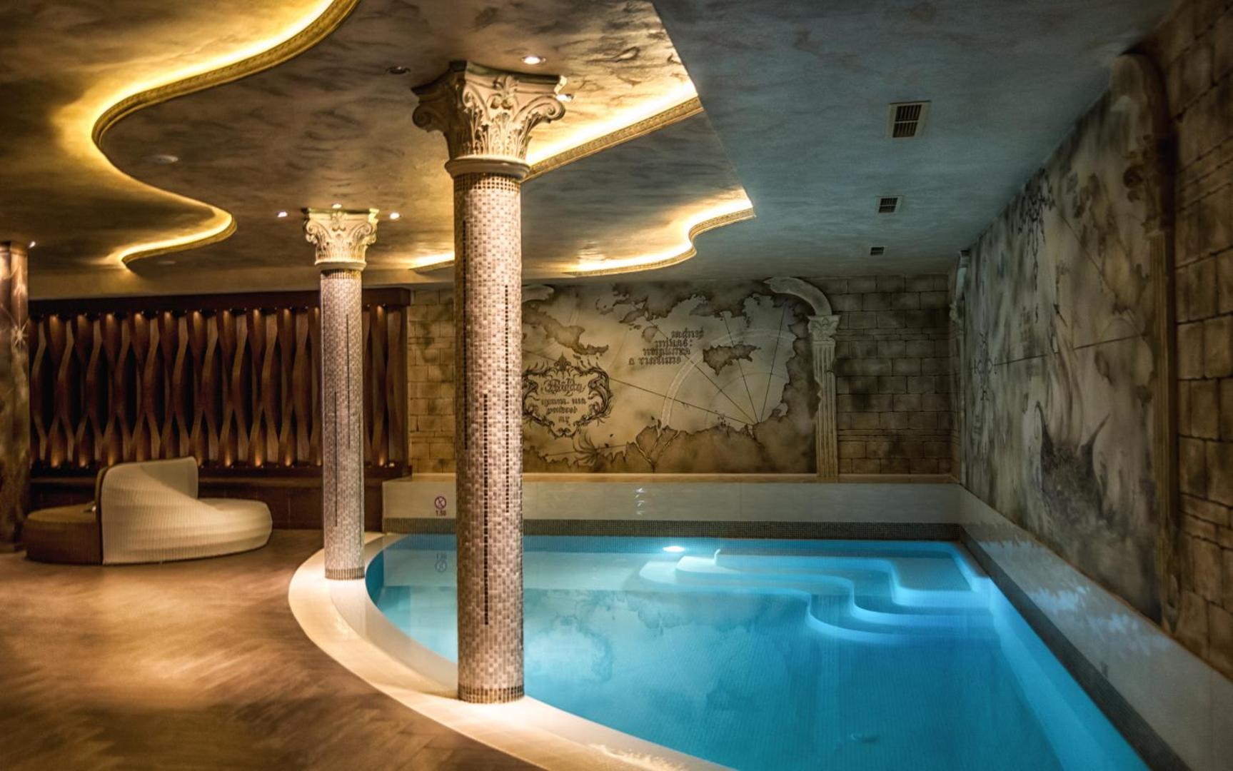Diamant Residence Hotel & Spa iekštelpu baseins spa centrā ar dekoratīvām kolonnām un sienu gleznojumiem relaksējošā apgaismojumā
