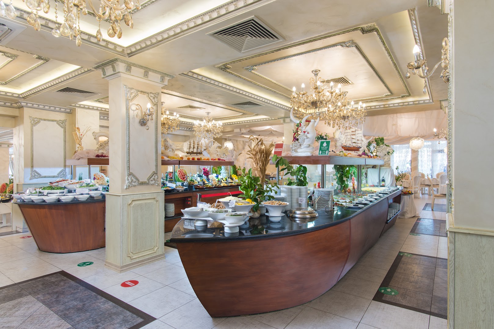 Diamant Residence Hotel & Spa restorāna interjers ar kuģa formas bufetes galdiem un greznām kristāla lustrām Saulainajā krastā