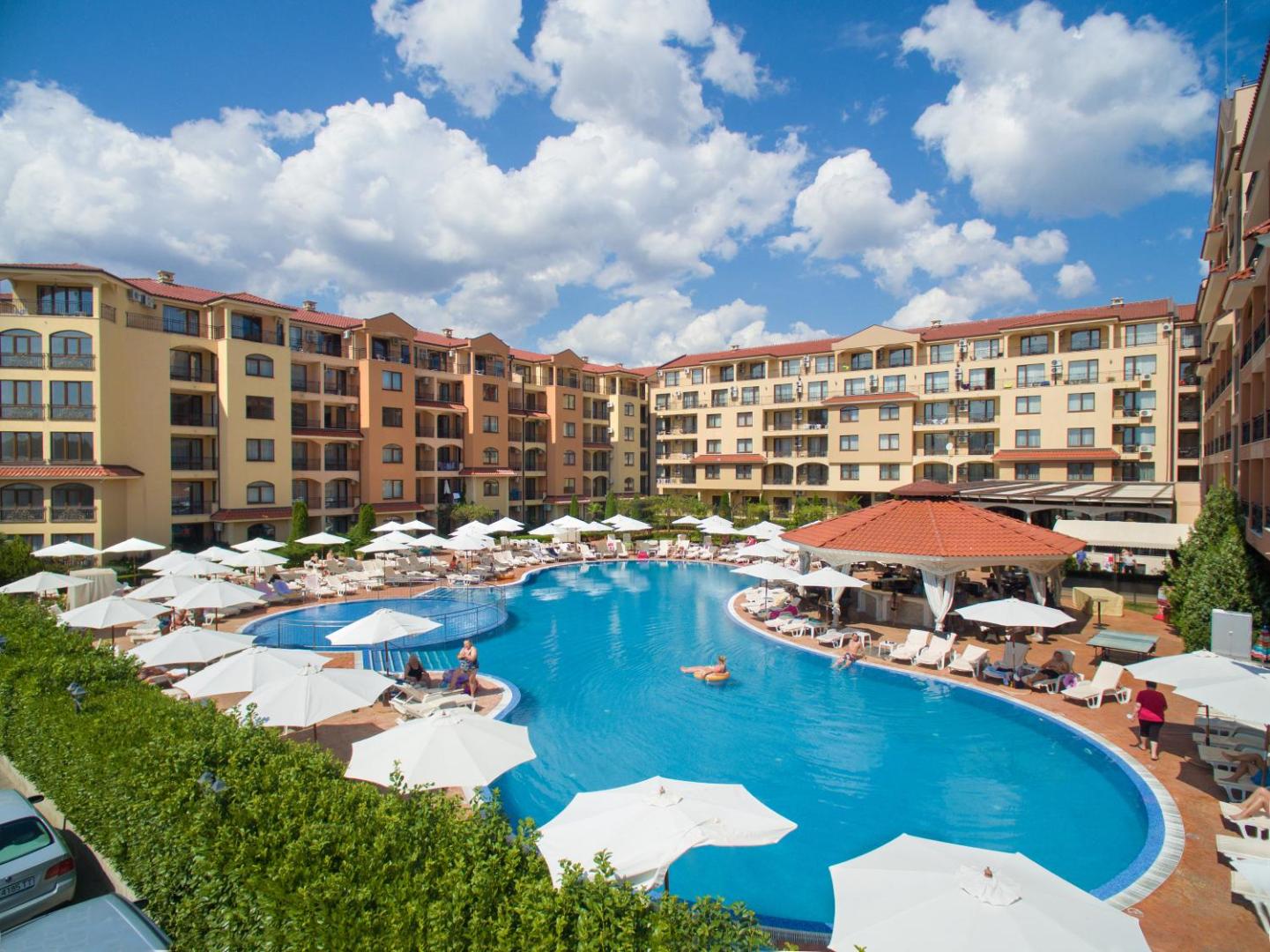 Diamant Residence Hotel & Spa plašais baseina komplekss ar saulessargiem un atpūtas krēsliem, skats no augšas uz kūrorta teritoriju