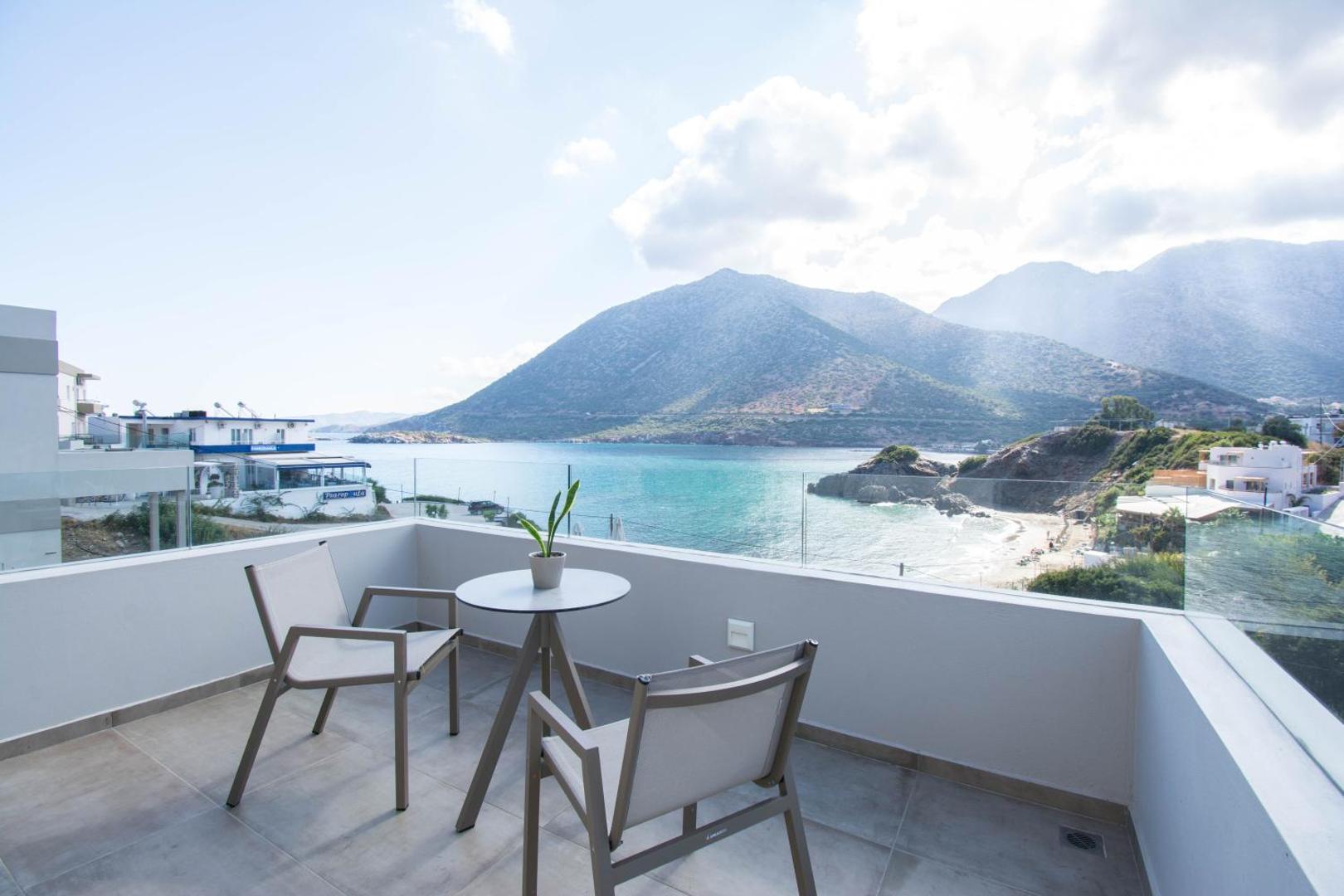 Bali Diamond Adults Only numura privātais balkons ar stikla margām, galdiņu un krēsliem, no kura paveras skats uz kalniem un līci