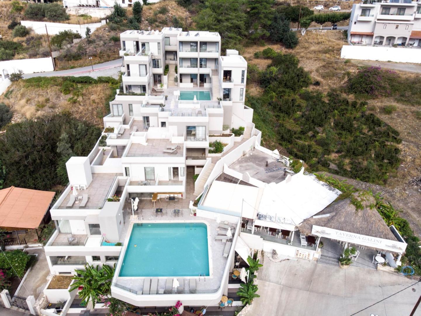 Bali Diamond Adults Only viesnīcas skats no augšas Bali ciemata piekrastē Krētā — modernā arhitektūra ar āra baseinu un sauļošanās terasi