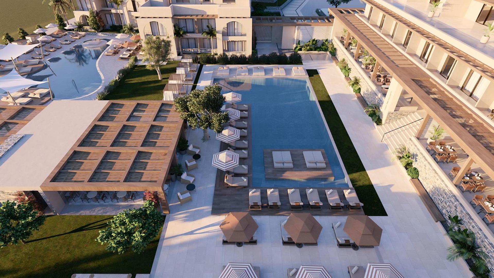 Vasia Resort & Spa galvenā baseina zona no augšas Sisi ciematā, Krētā — plaša atpūtas teritorija ar saulessargiem, zviļņiem un koka terasēm