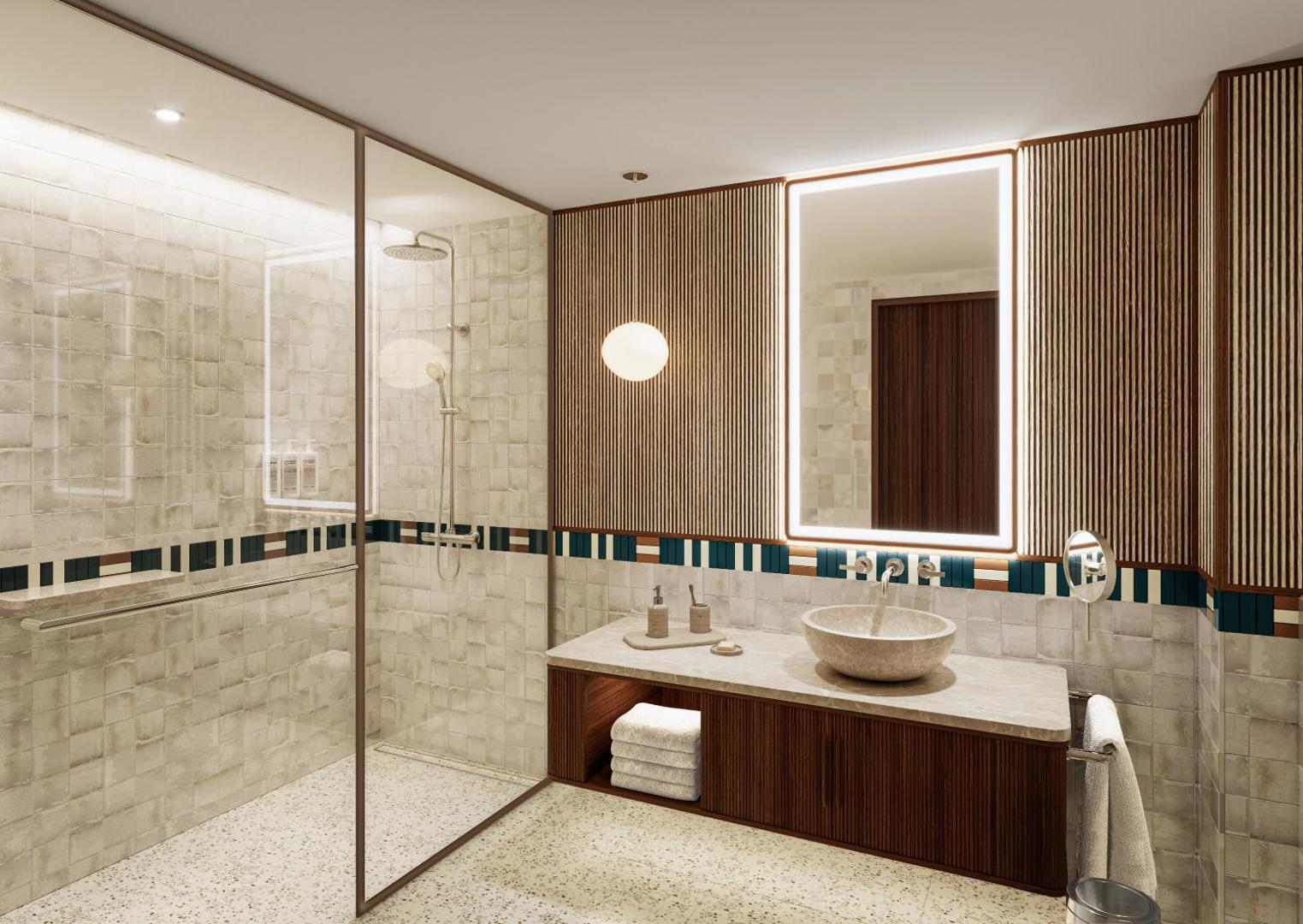 Vasia Hotel & Spa numura vannas istaba ar modernu dušas zonu, akmens izlietni un gaumīgu flīžu apdari