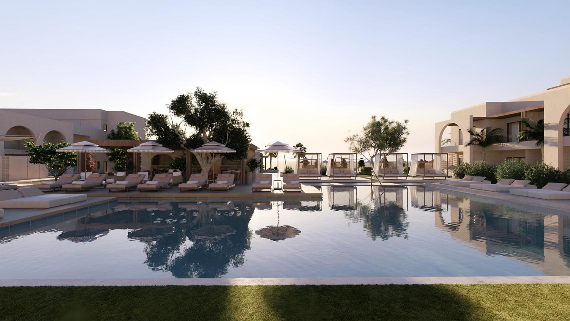 Vasia Hotel & Spa āra baseins saulrietā ar atspulgu ūdenī un ērtām gultām atpūtai — viesnīcas teritorija Sisi ciematā