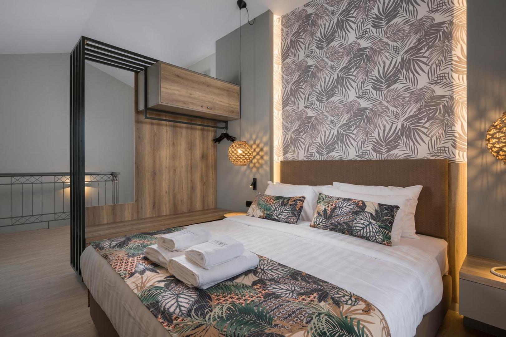 Mare Blue Suites moderns divvietīgs numurs ar dekoratīvām tapetēm, koka elementiem un kvalitatīvu gultas veļu.