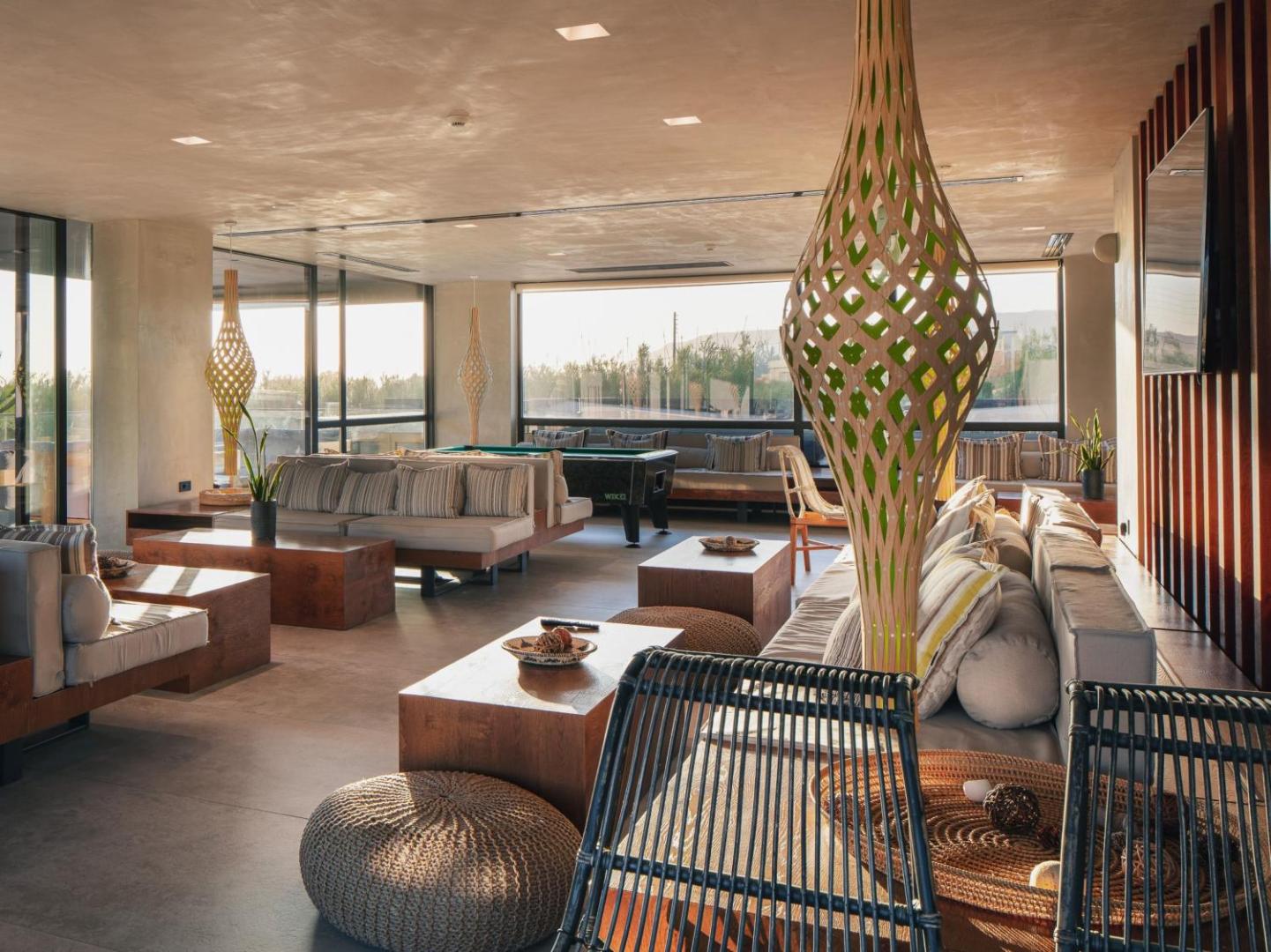 La Mer Resort & Spa viesnīcas lobby atpūtas zona ar moderniem dīvāniem, koka galdiem un biljarda galdu Krētā