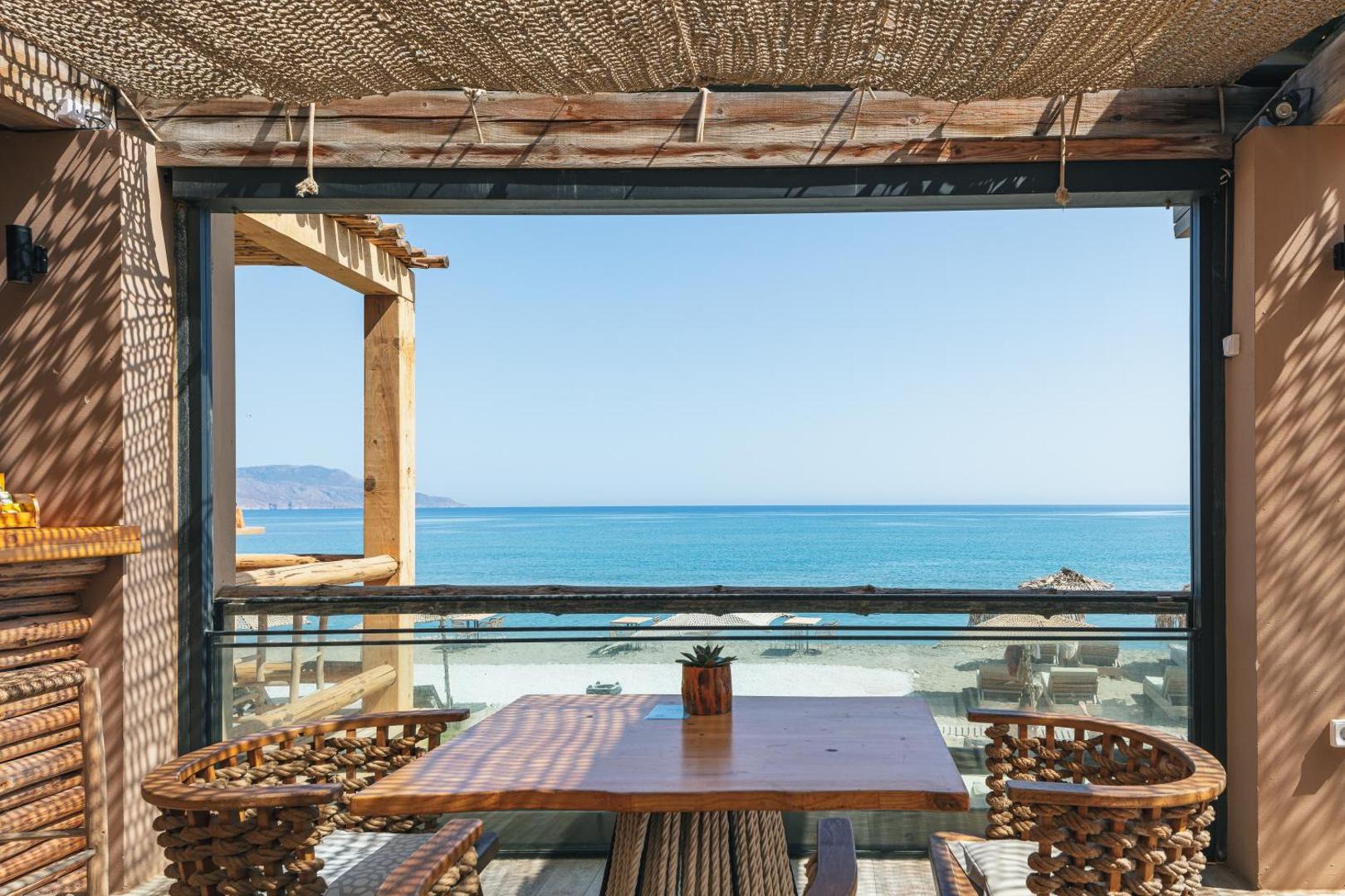Skats uz Vidusjūru no La Mer Resort & Spa restorāna terases — koka mēbeles un saulaina atmosfēra piekrastē