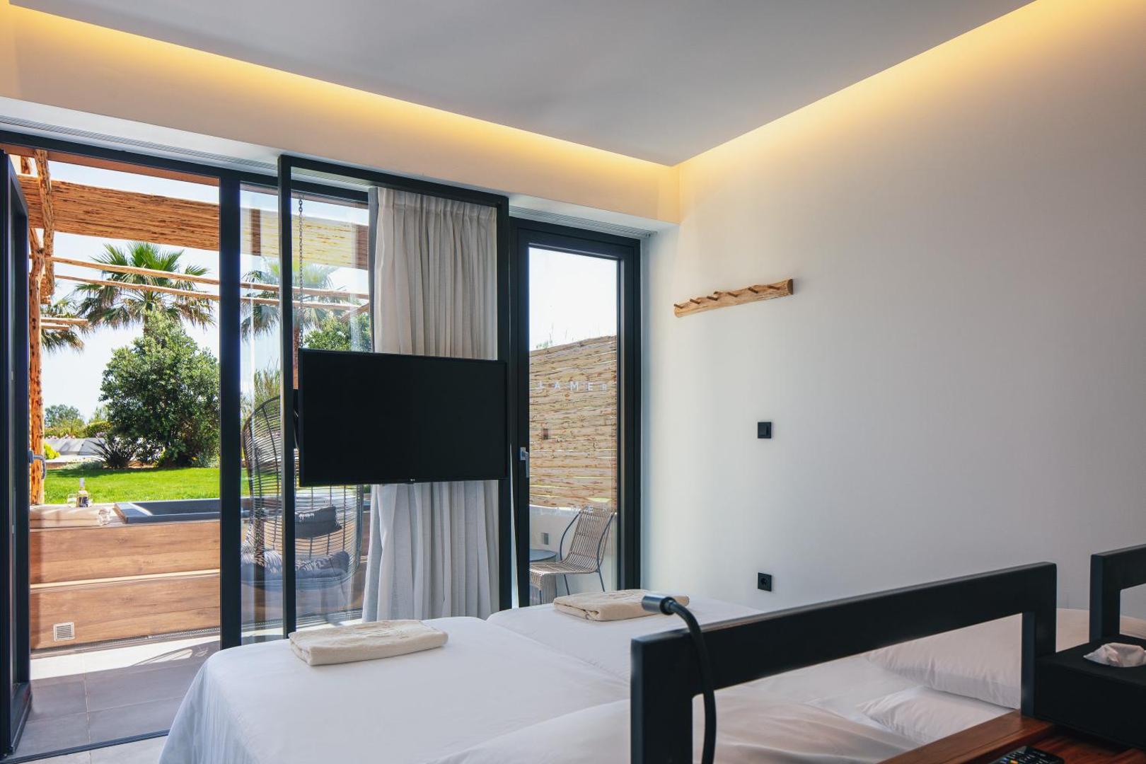 Viesnīcas La Mer Resort & Spa numurs ar izeju uz dārzu un āra atpūtas zonu Krētas kūrortā