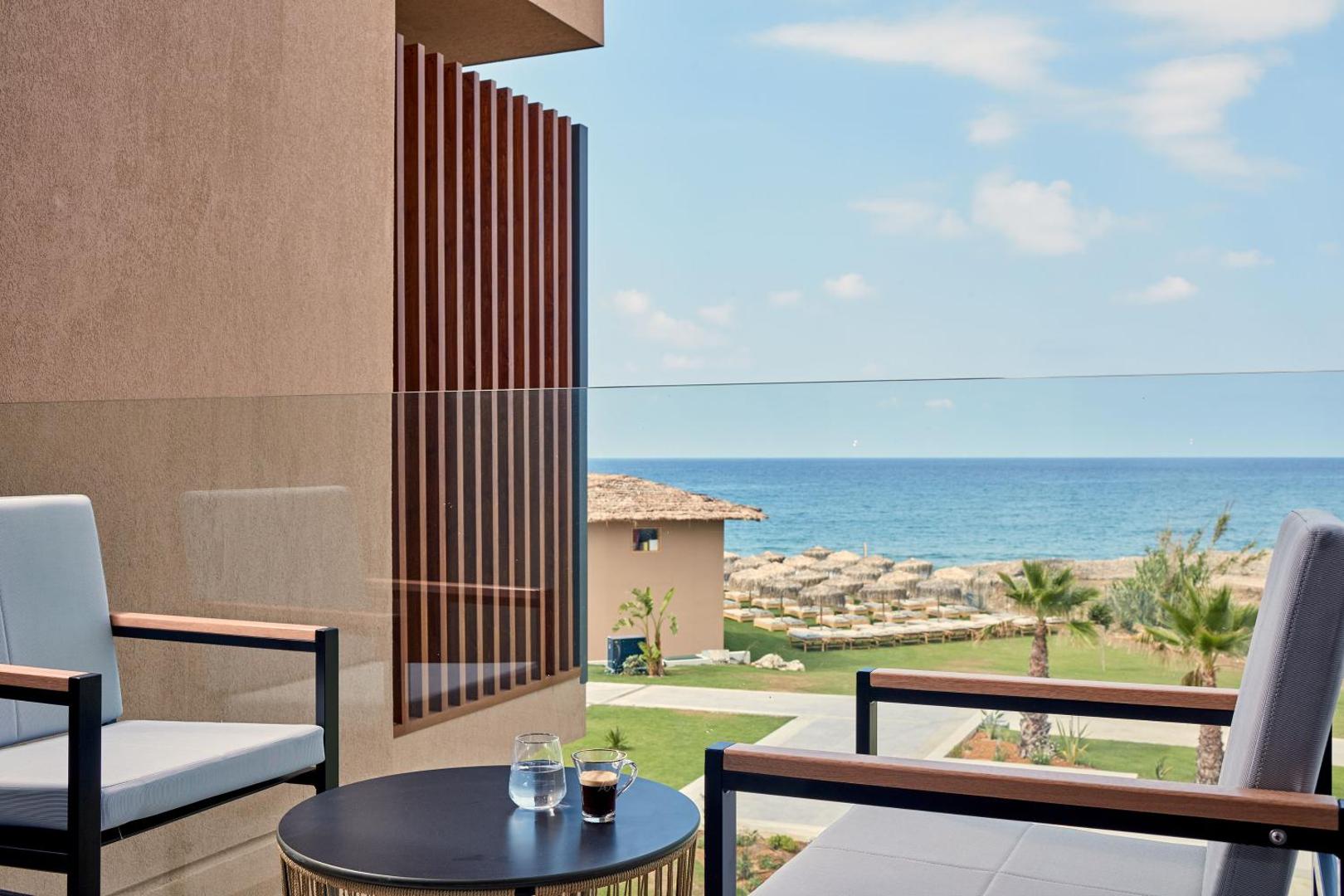 Skats no La Mer Resort & Spa numura balkona uz Vidusjūru un pludmali ar saulessargiem Krētas piekrastē