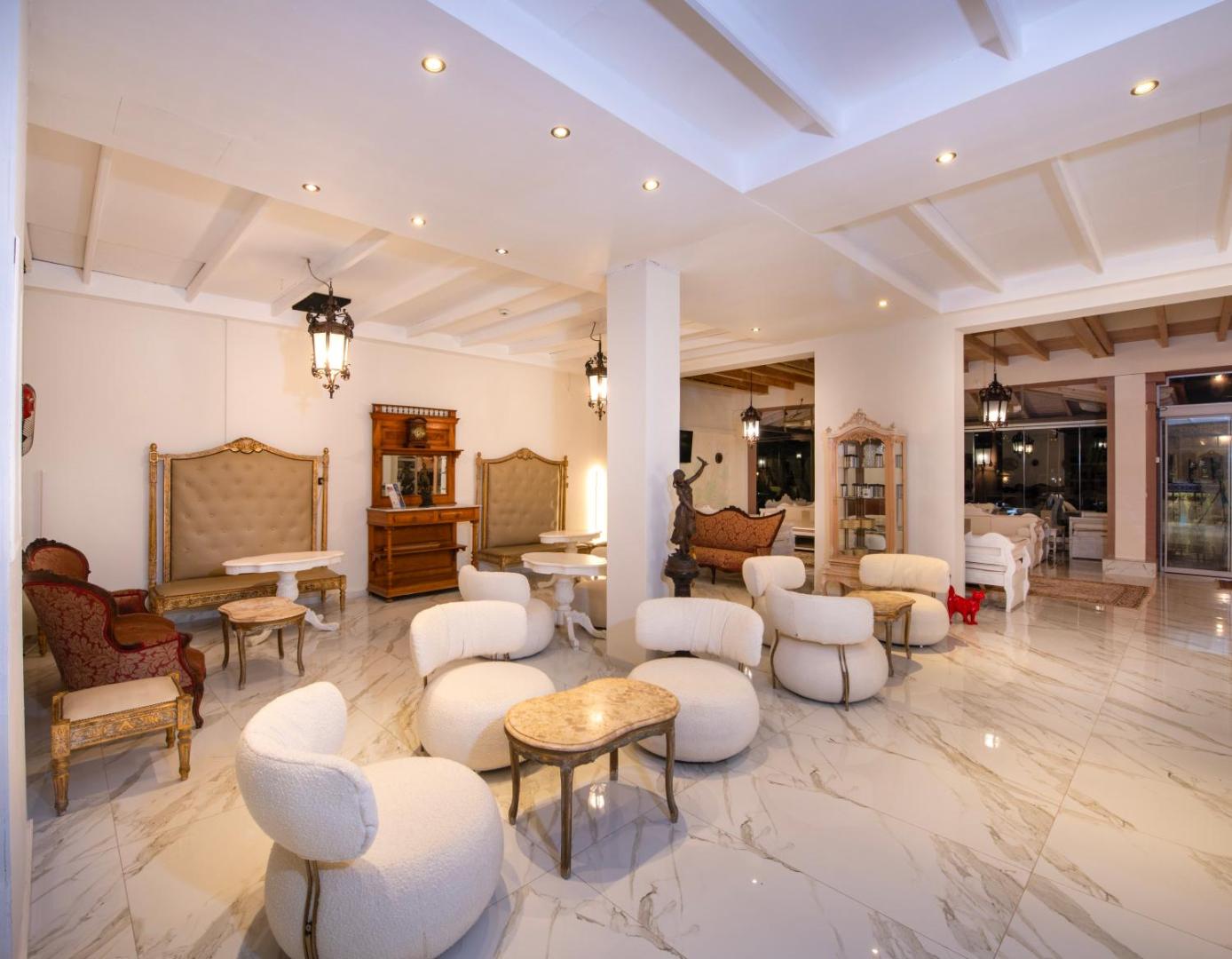 Orpheas Resort Hotel atpūtas telpa ar marmora grīdām, antīka stila mēbelēm un mīkstiem atpūtas krēsliem gaišos toņos
