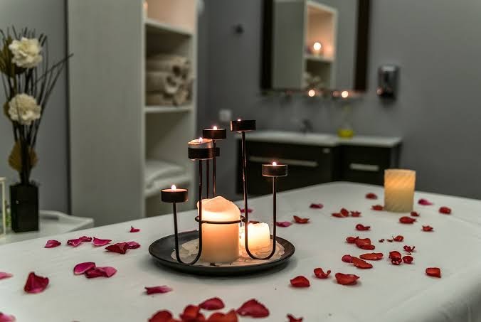 Georgioupolis Resort spa centra masāžas galds ar svecēm un rožlapiņām — relaksējoša atmosfēra labsajūtas procedūrām Krētas kūrortā
