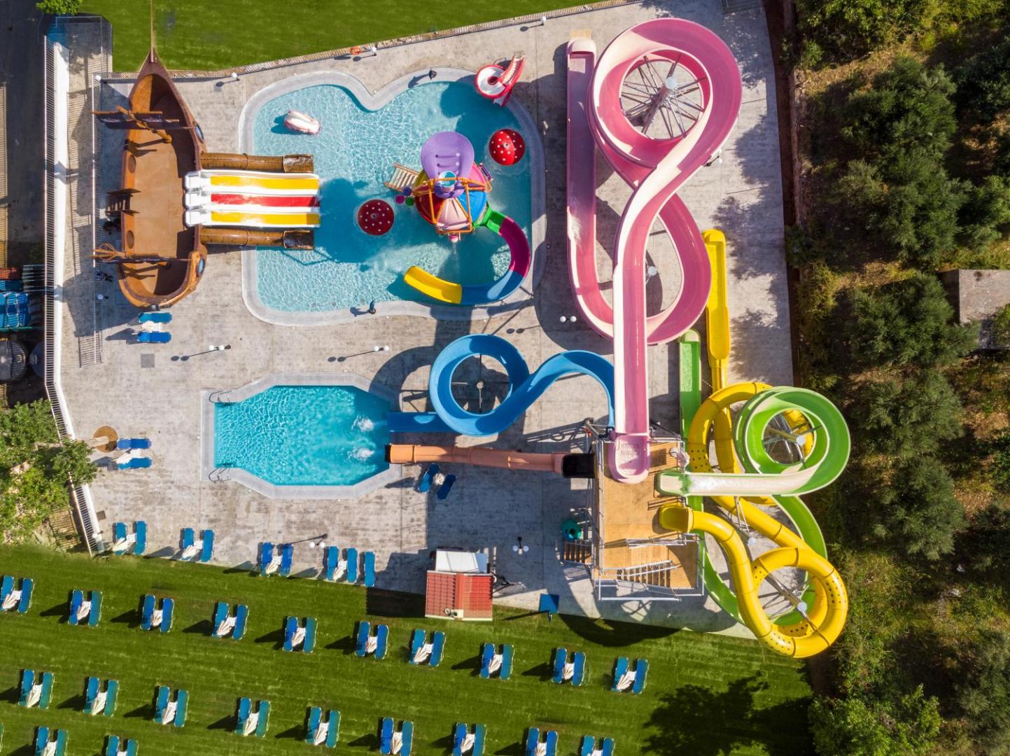 Georgioupolis Resort Aqua Park un SPA akvaparks no putna lidojuma ar krāsainiem slidkalniņiem un pirātu kuģi