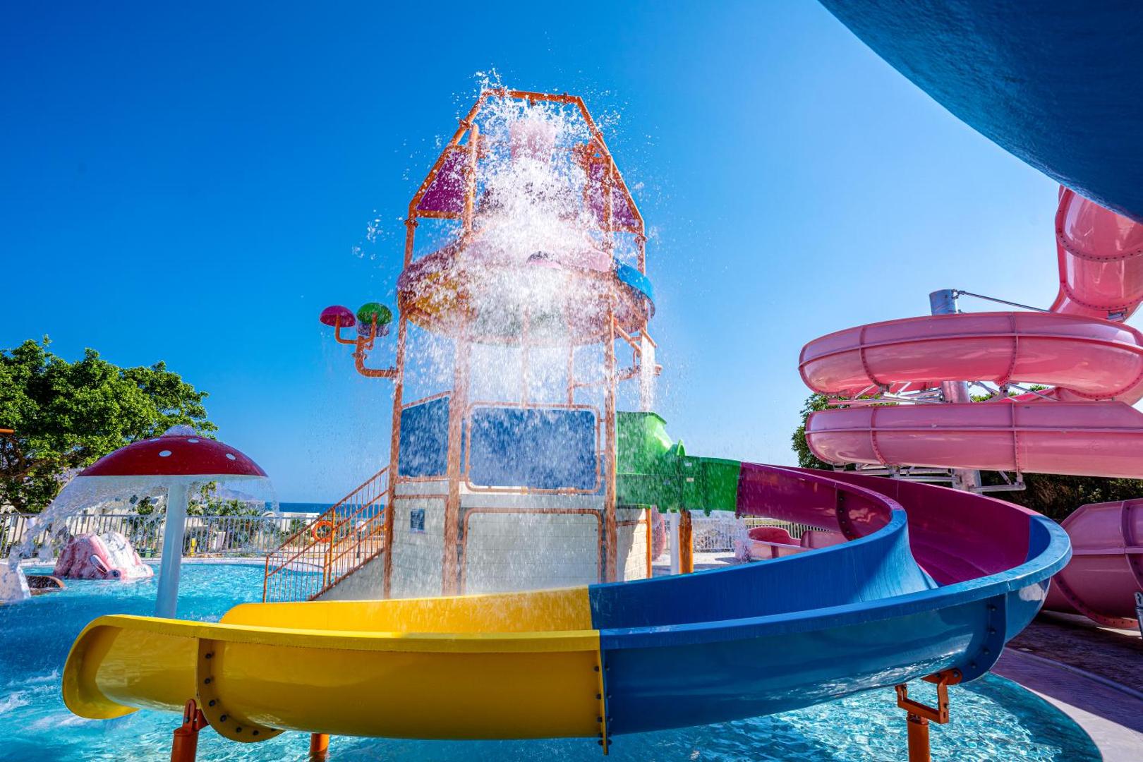 Georgioupolis Resort bērnu ūdens atrakciju parks ar strūklakām, sēnes formas dušu un nelieliem slidkalniņiem drošai bērnu izklaidei