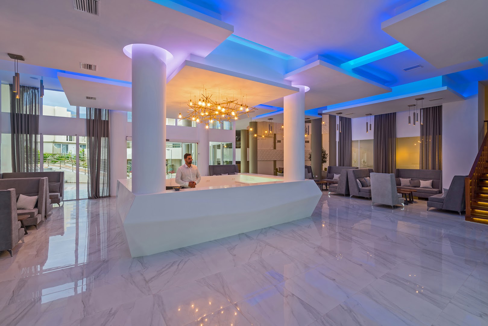 Georgioupolis Resort Aqua Park and SPA recepcijas zona ar modernu leti, zilu neona apgaismojumu un ērtiem dīvāniem viesiem