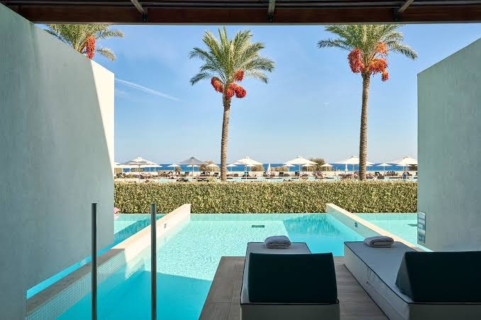 Gennadi Grand Resort numurs ar tiešu piekļuvi baseinam, sauļošanās krēsliem uz koka terases un skatu uz jūru un palmām