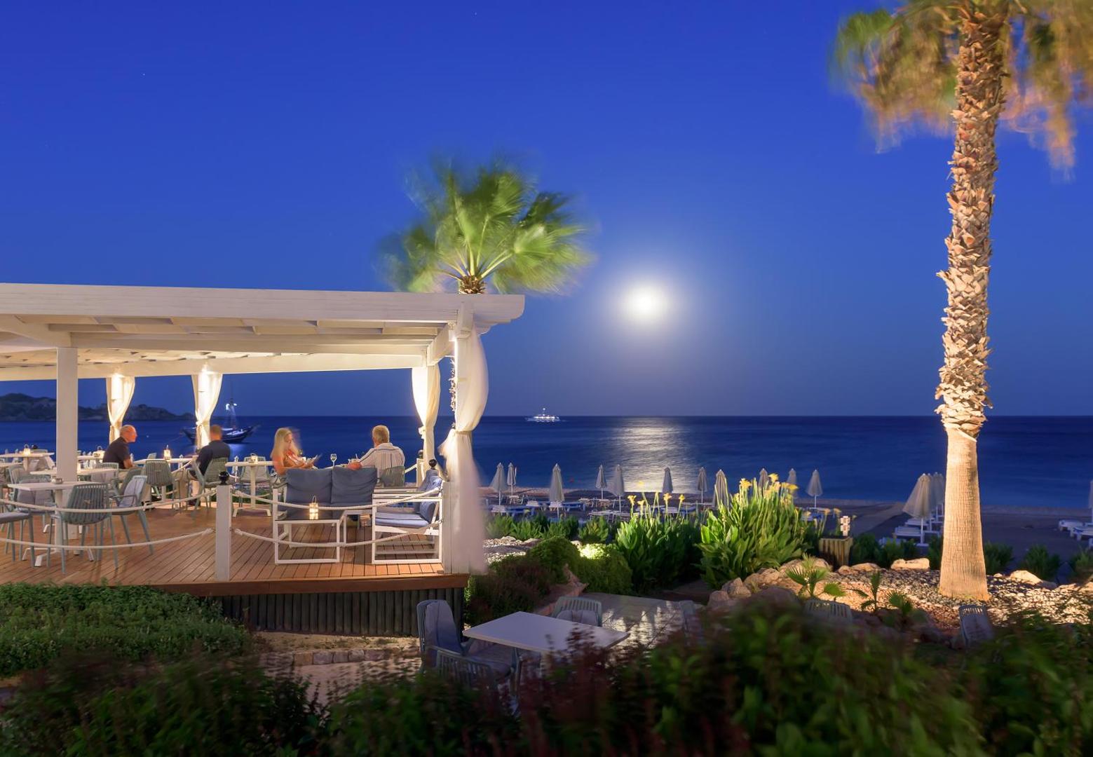 Rodos Palladium Leisure & Wellness pludmales bārs naktī pilnmēness laikā pie jūras krasta Rodas salā