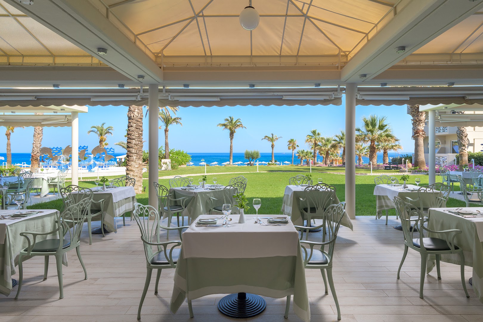 Rodos Palladium Leisure & Wellness viesnīcas restorāna terase ar skatu uz dārzu un Vidusjūru Rodas salā, Grieķijā