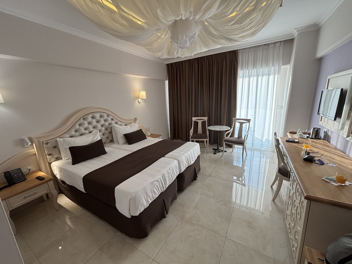 Rodos Palladium Leisure & Wellness klasiska stila numurs ar divguļamo gultu, darba zonu un dekoratīviem griestu elementiem.