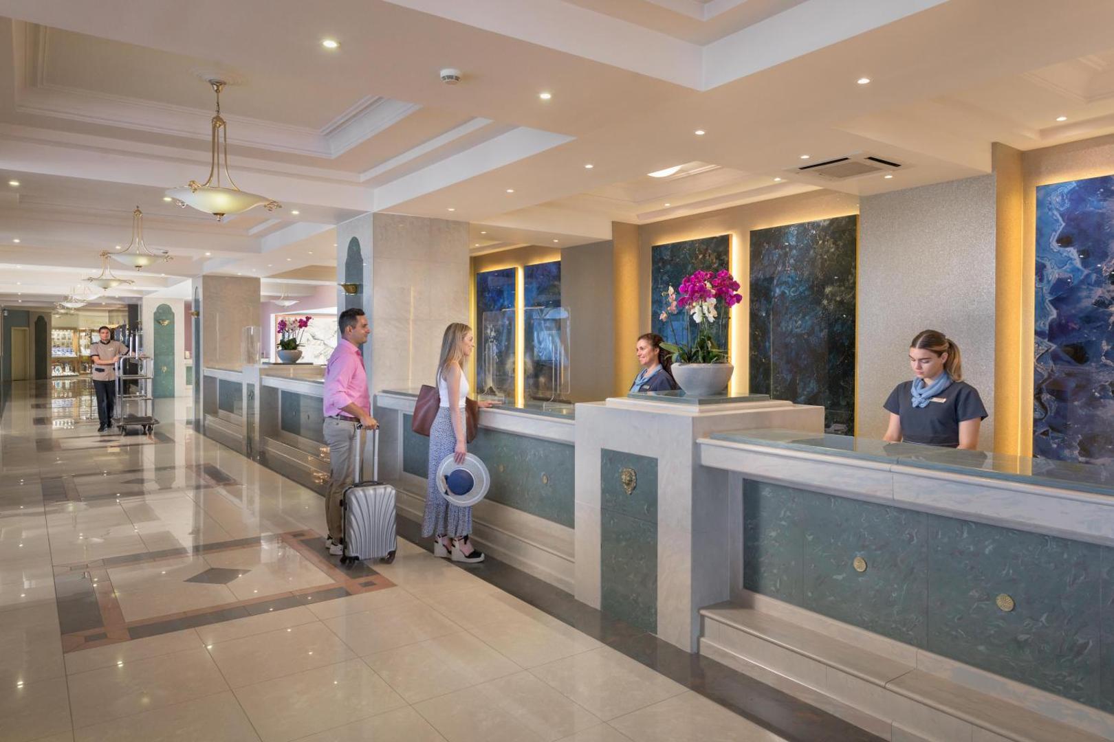 Rodos Palladium Leisure & Wellness viesnīcas recepcija Rodā — viesu reģistrācijas zona ar marmora apdari un laipnu personālu
